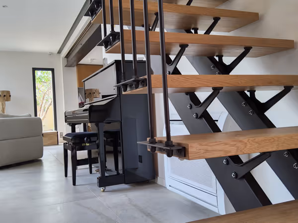 Escalier avec marches en bois massif et rampe garde-corps industrielle en acier