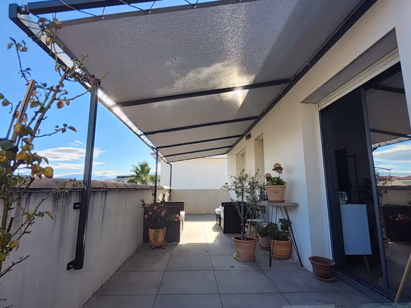 Pergola extérieure en métal avec toile d'ombrage tendue beige sur terrasse bois